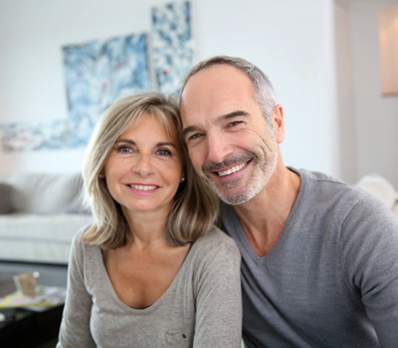 smiling couple with dental implants in Flint, MI 