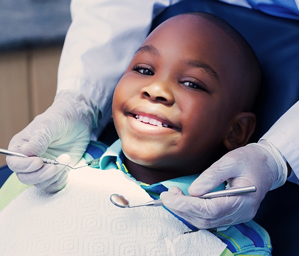 Young boy smiling during pulp therapy treatment