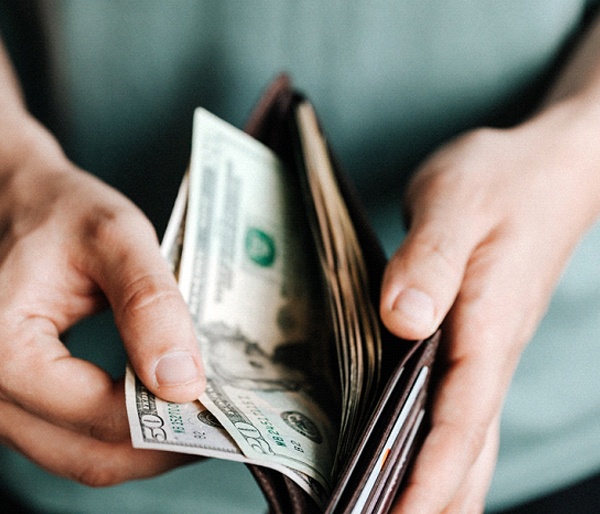 Man holding open wallet to cover the cost of dentures in Flint