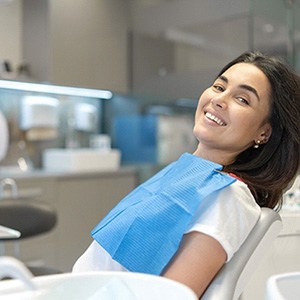 Female dental patient smiling after receiving affordable treatment