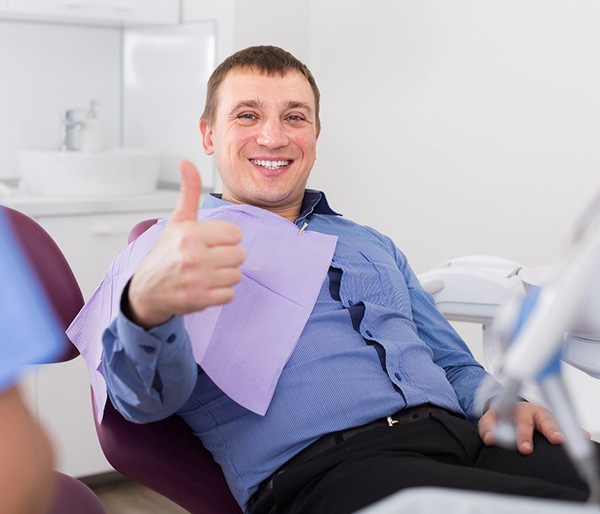 Man gives thumbs-up after tooth extraction in Flint