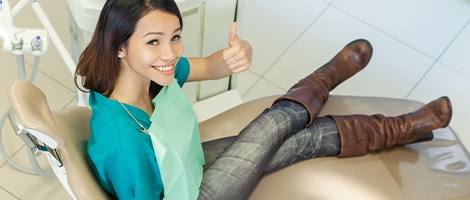 Woman giving thumbs up during preventive dentistry exam