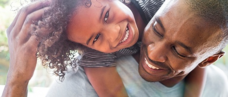 Father holding daughter after children's dentistry visit