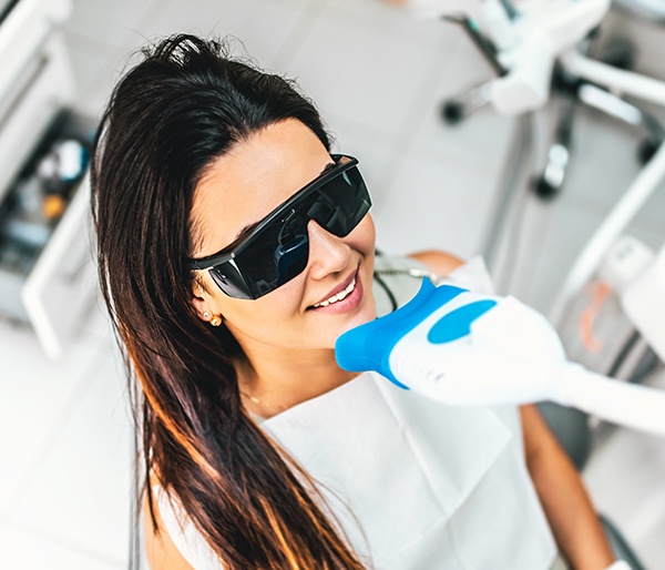 Woman receiving in office teeth whitening treatment