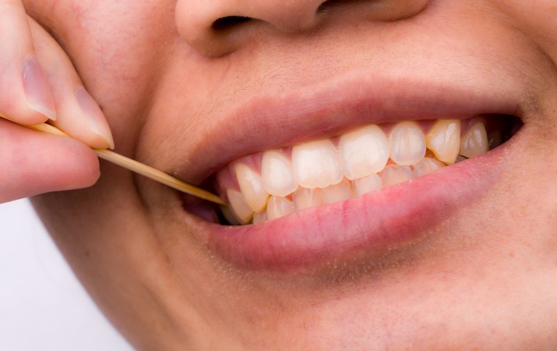 Woman picking food from her teeth