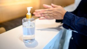 patient sanitizing their hands at a front desk