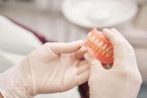 Dentist holding a pair of natural-looking dentures