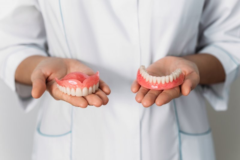 person holding a full set of dentures