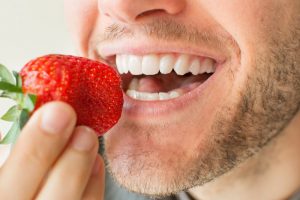 man preparing to eat strawberry