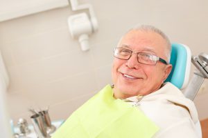 older man smiling in dental chair