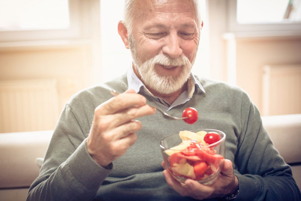 man eating with dentures in Flint